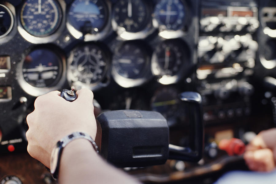 Pilot handling controls, close-up (focus on hand) Photograph by Chris Sattlberger