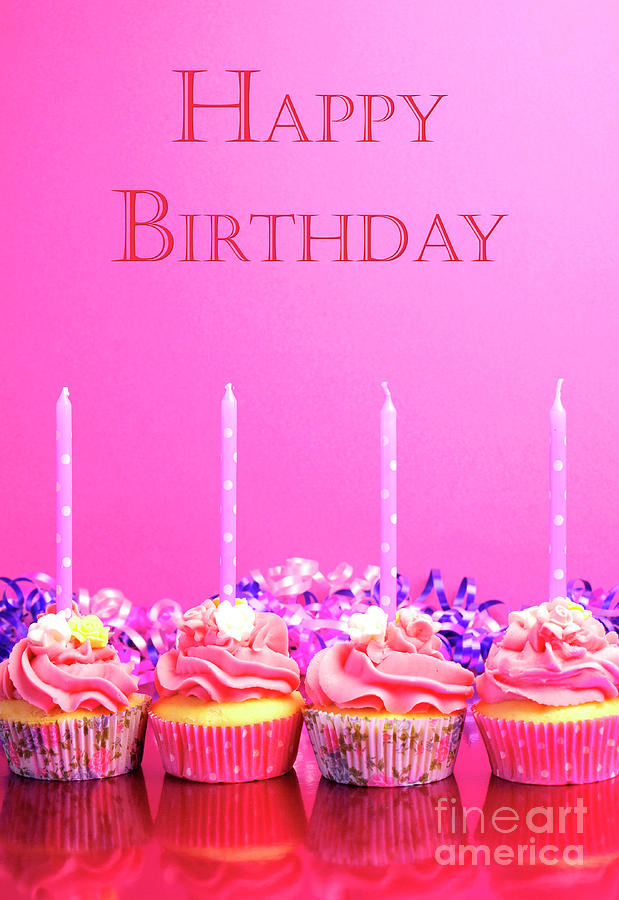 Pink birthday cupcakes with candles. Photograph by Milleflore Images
