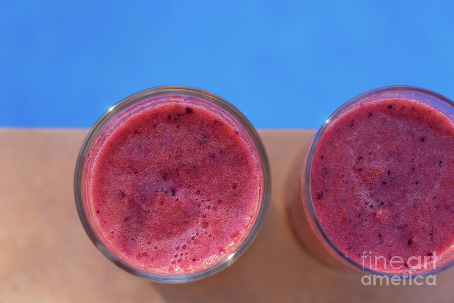 Pink fruit smoothies by the beautiful blue pool Photograph by Adriana Mueller