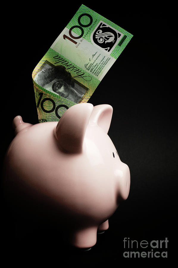 Pink Piggy Bank with Australian money against a black background Photograph by Milleflore Images