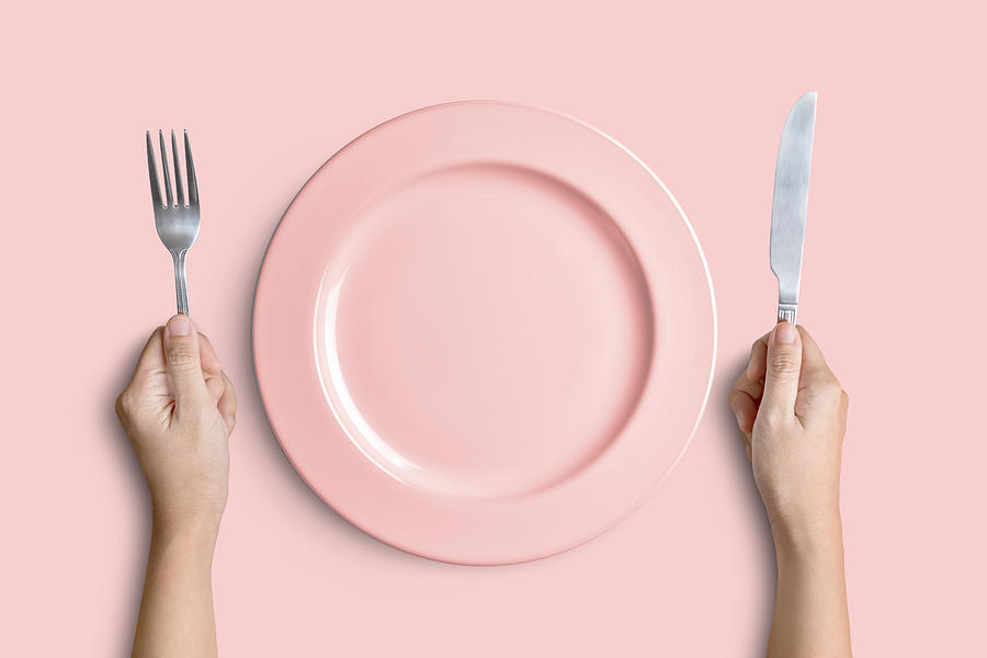 Pink plate with silver fork and knife on pink background Photograph by Suradech14
