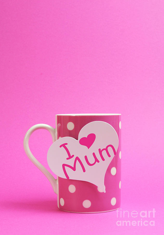 Pink polka dot coffee or tea mug with heart shape white gift tag with I Heart Love Mum for Mothers Day on pink background with copy space for your text here. Photograph by Milleflore Images