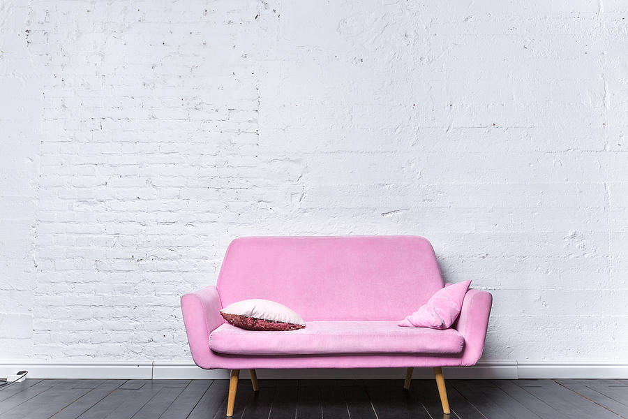 Pink retro sofa against white brick wall Photograph by Studio-54-foto