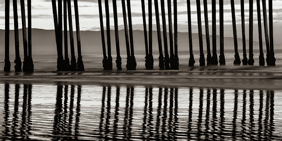 Pismo Beach Pier Piling Silhouettes and Coastal Mountain Panorama - Classic Sepia Photograph by Gregory Ballos