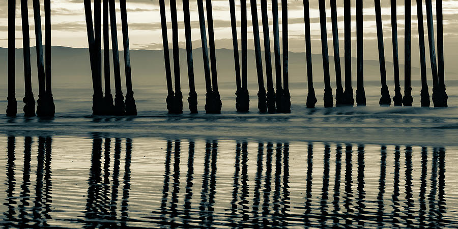 Pismo Beach Pier Piling Silhouettes and Coastal Mountain Panorama - Sepia Photograph by Gregory Ballos