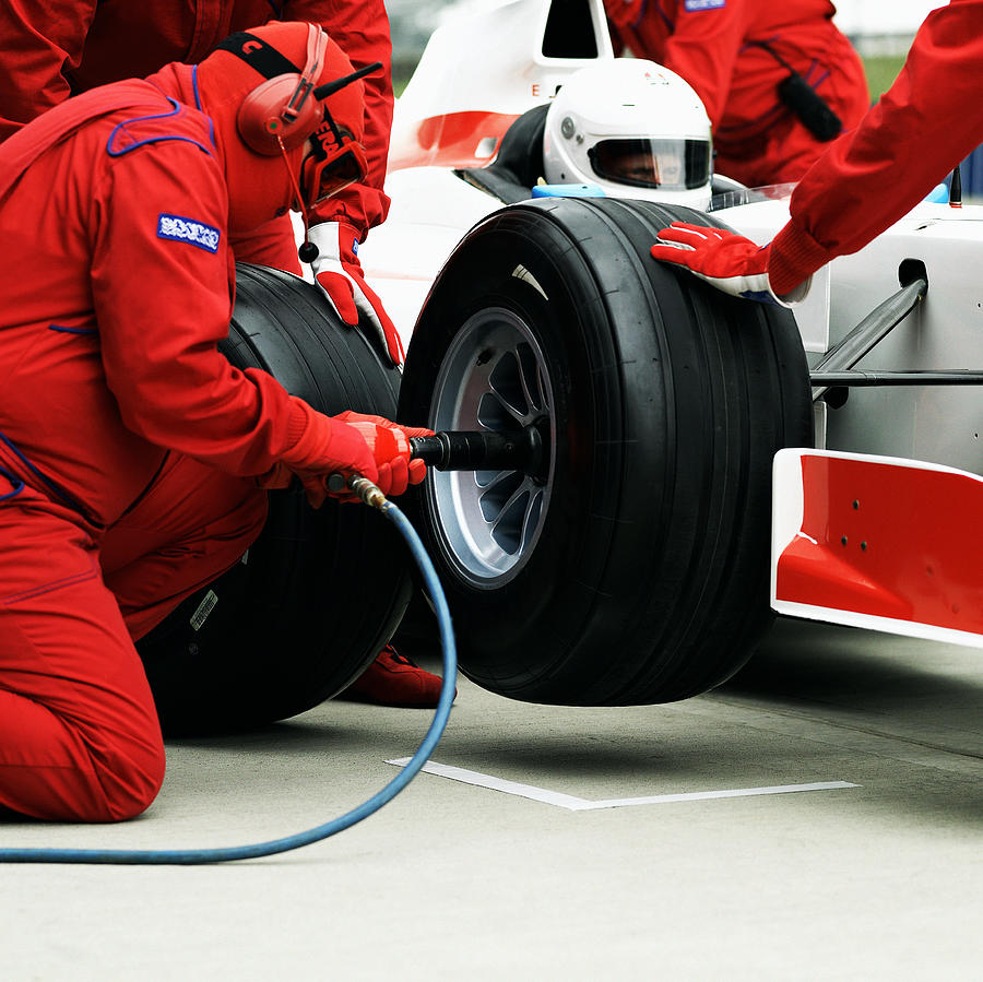 Pit crew changing racing car wheel Photograph by Alan Thornton