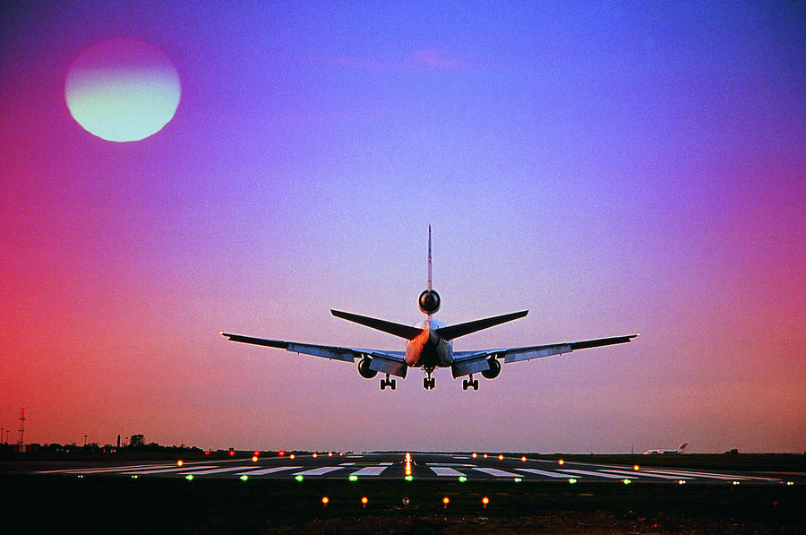 Plane landing on runway Photograph by Digital Vision.