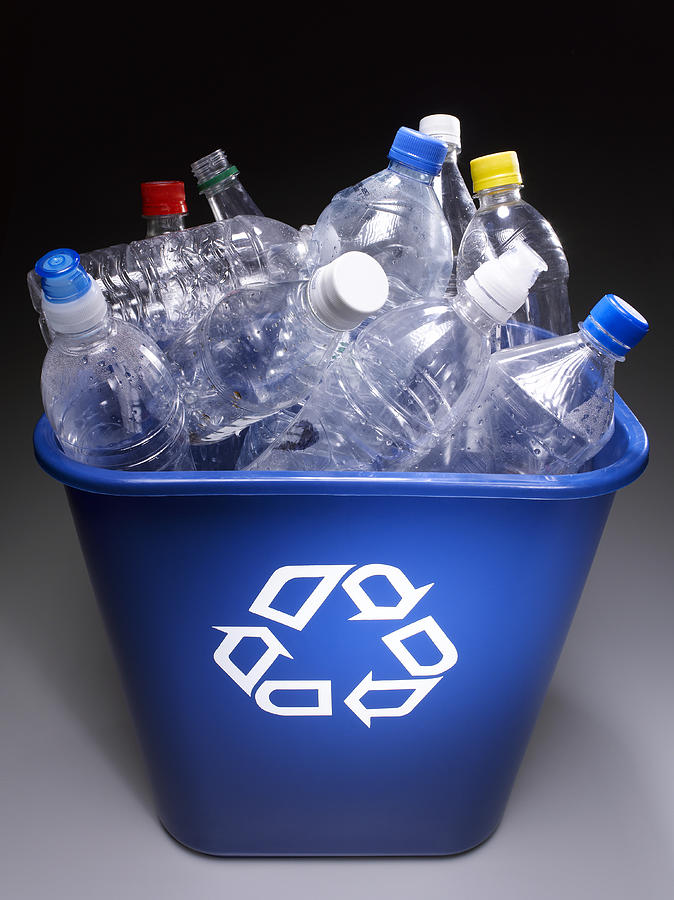 Plastic bottles in trash bin with recycle sign, elevated view Photograph by Jeffrey Hamilton