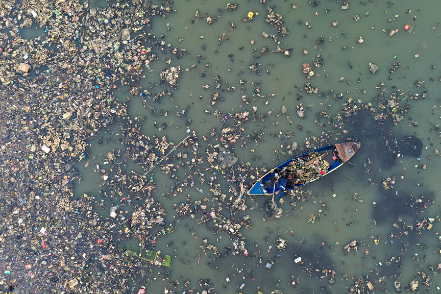 Plastic Pollution in the Ocean; Man Cleaning Plastic Pollution in the Sea Photograph by Yunaidi Joepoet