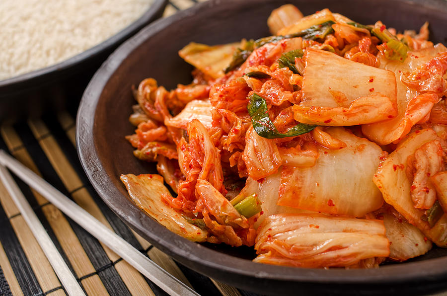 Plate full of kimchi and chopsticks on side Photograph by Fudio