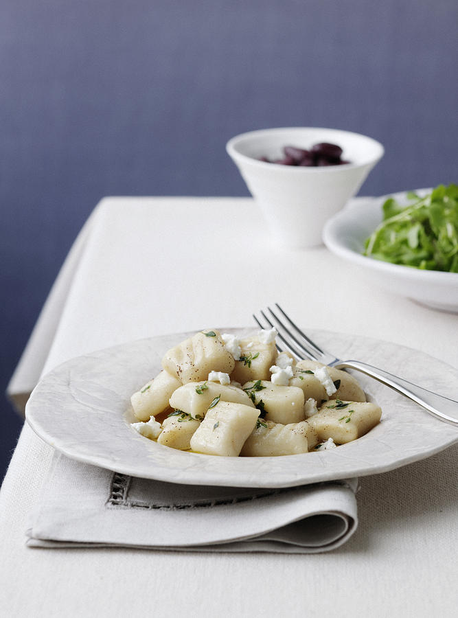 Plate of gnocchi with olives Photograph by Cultura RF/BRETT STEVENS