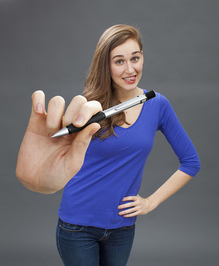 Playful Beautiful Young Woman Giving Pen For Signature Of Contract Photograph by Studio Grand Web