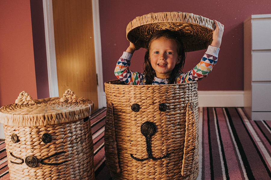 Playful Child hiding in a Rattan Laundry Basket in bedroom Photograph by Catherine Falls Commercial