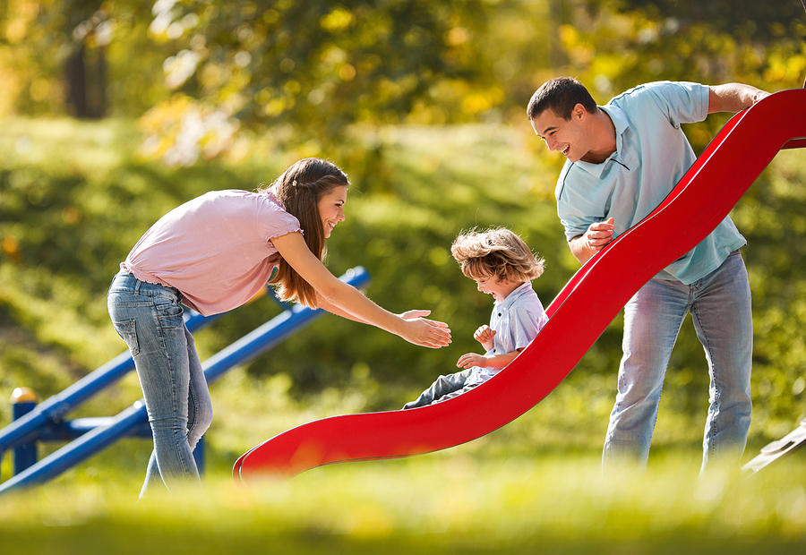 Playful family enjoying in the playground. Photograph by Skynesher