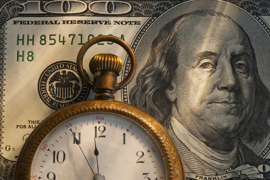Pocket watch on one hundred dollar bill, studio shot Photograph by Tetra Images