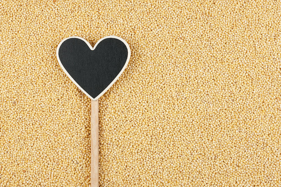 Pointer in the form of heart lies on millet grains Photograph by Alekleks