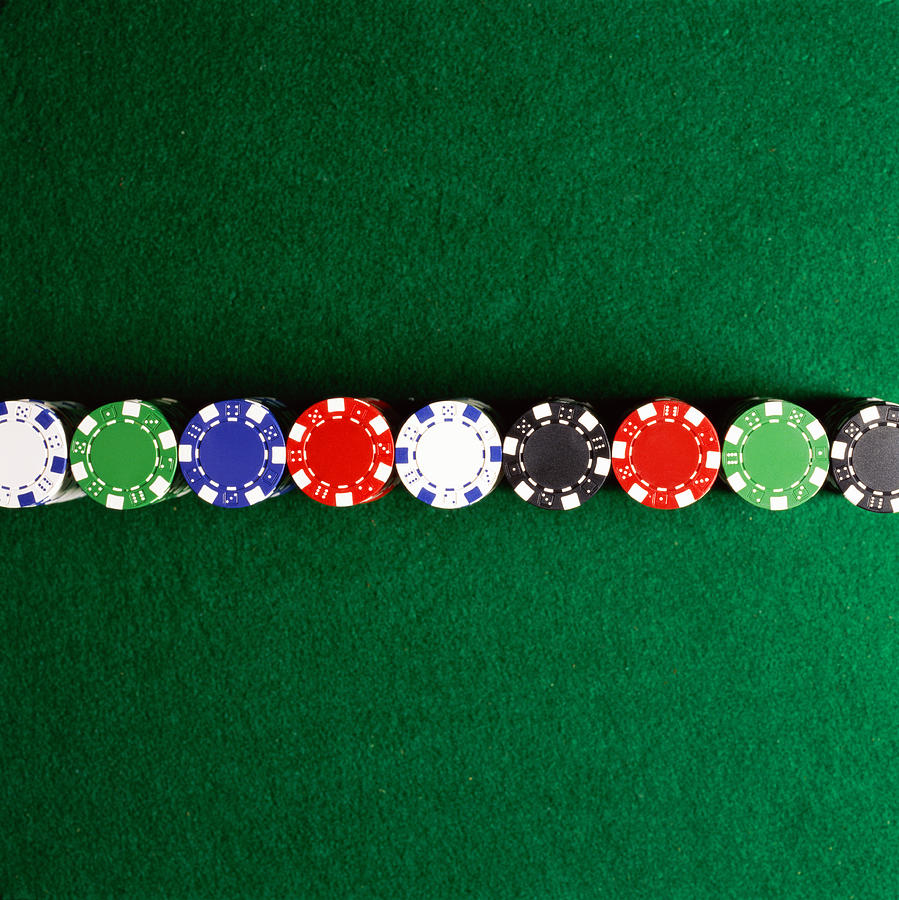 Poker chips lined up on casino table Photograph by Paul Taylor