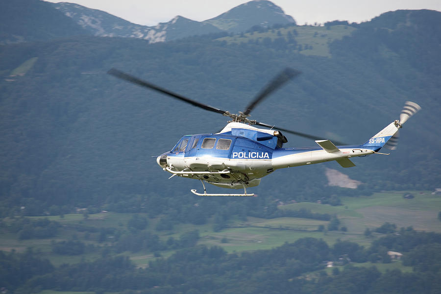 Police helicopter patrolling Ljubljana Joze Pucnik Airport, Slov Photograph by Ian Middleton