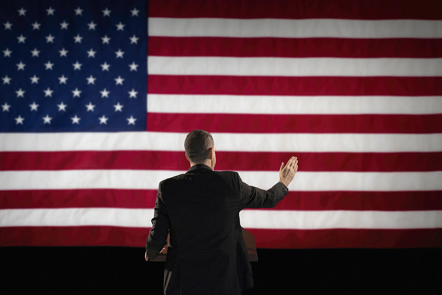 Politician giving speech with American flag in background Photograph by Tetra Images