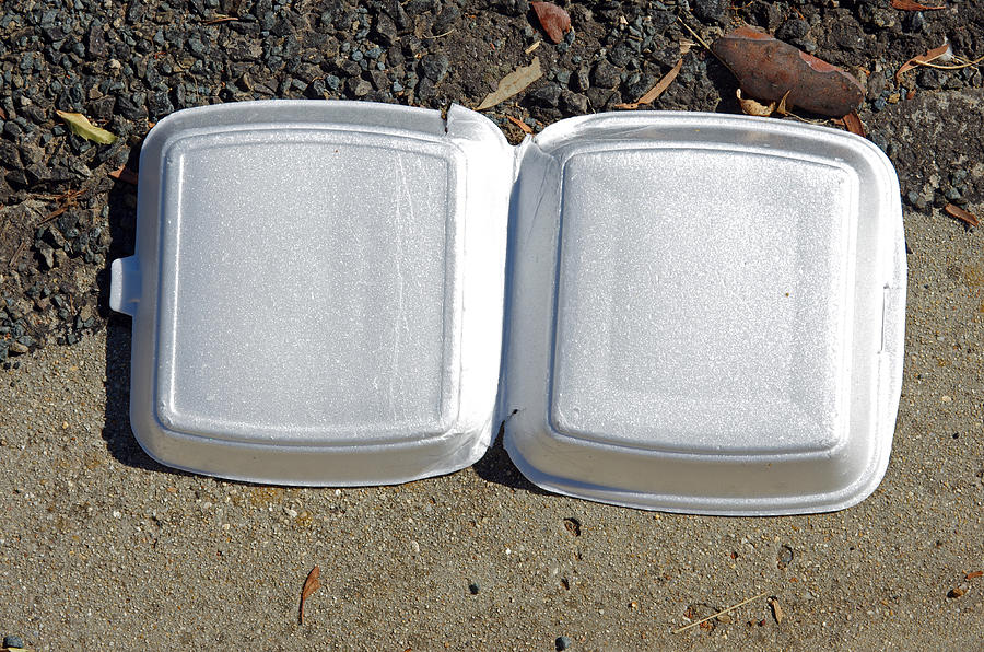 Polystyrene takeout burger container littering a road gutter Photograph by Simon McGill