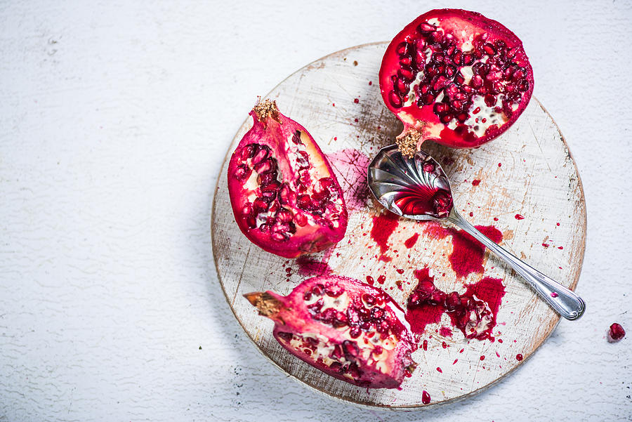 Pomegranate cut on board Photograph by Merc67