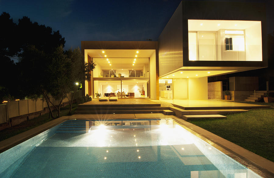 Pool outside modern house at night Photograph by Martin Barraud