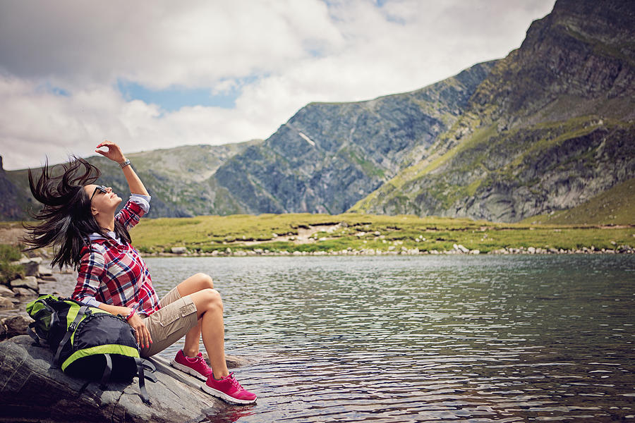 Portrait of a beautiful hiker girl sitting next to the high mountain lake Photograph by Praetorianphoto