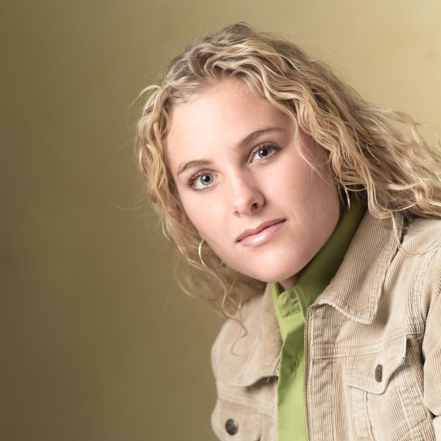Portrait Of A Blonde Caucasian Teenage Girl In A Green Shirt And Tan Jacket As She Smiles Slightly Photograph by Photodisc
