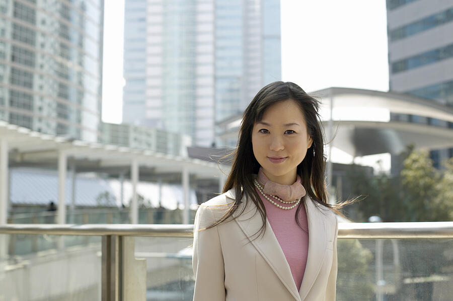 Portrait of a Businesswoman with Office Blocks in the Background Photograph by Digital Vision.