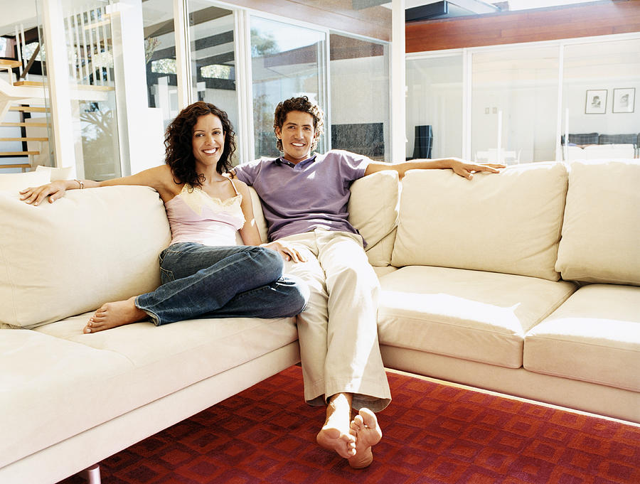 Portrait of a Couple Sitting on a Sofa in Their Home Photograph by Digital Vision.