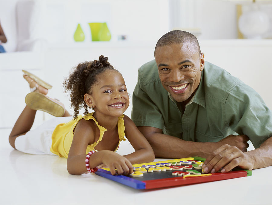 Portrait Of A Father And His Daughter Playing A Board Game Photograph by Stockbyte