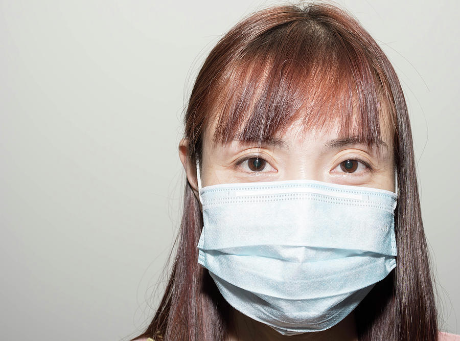 Portrait of a Female asian wearing a mask to protect her against ...