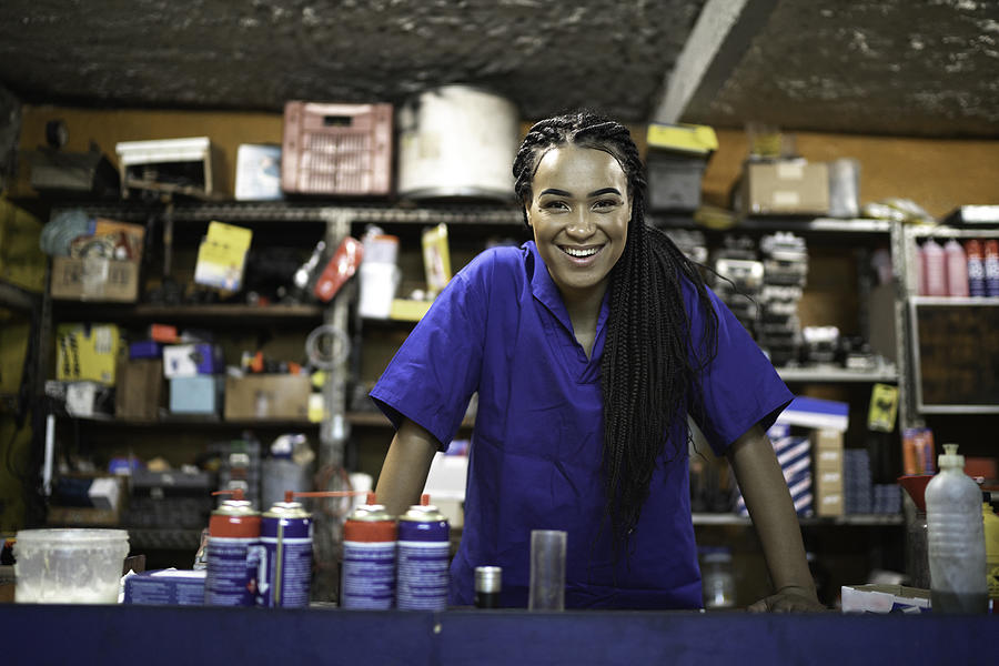Portrait of a female mechanic standing behind de counter in a auto repair shop Photograph by FG Trade
