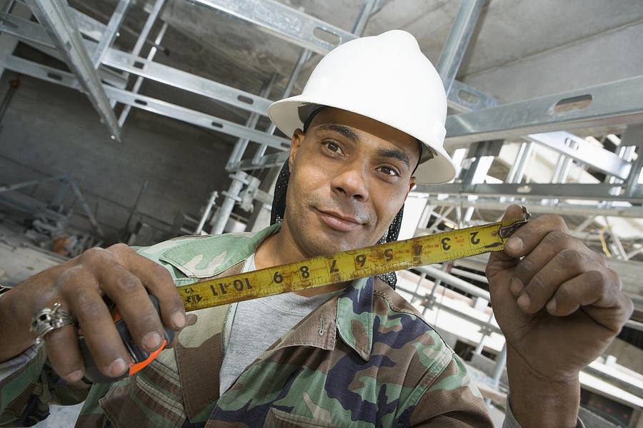 Portrait of a male construction worker holding a tape measure Photograph by Glowimages