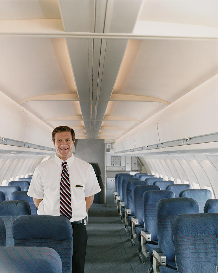 Portrait of a Male Flight Attendant on a Plane Photograph by Digital Vision.