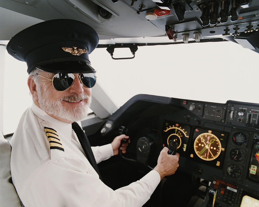 Portrait of a Male Pilot Sitting in the Cockpit Photograph by Digital Vision.