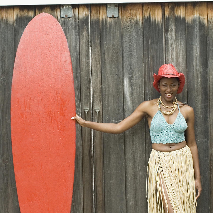 Portrait of a mid adult woman holding a surfboard and smiling Photograph by 40260
