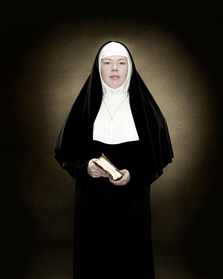 Portrait of a nun holding a bible Photograph by Image Source