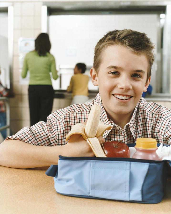 Portrait of a Primary Schoolboy With an Healthy Packed Lunch, Holding a Banana Photograph by Digital Vision.