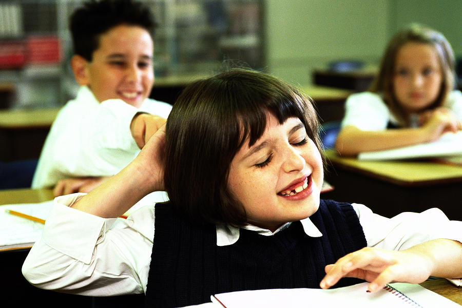 Portrait Of A School Boy (8-10) Pulling A Girls Hair In Class Photograph by Stockbyte