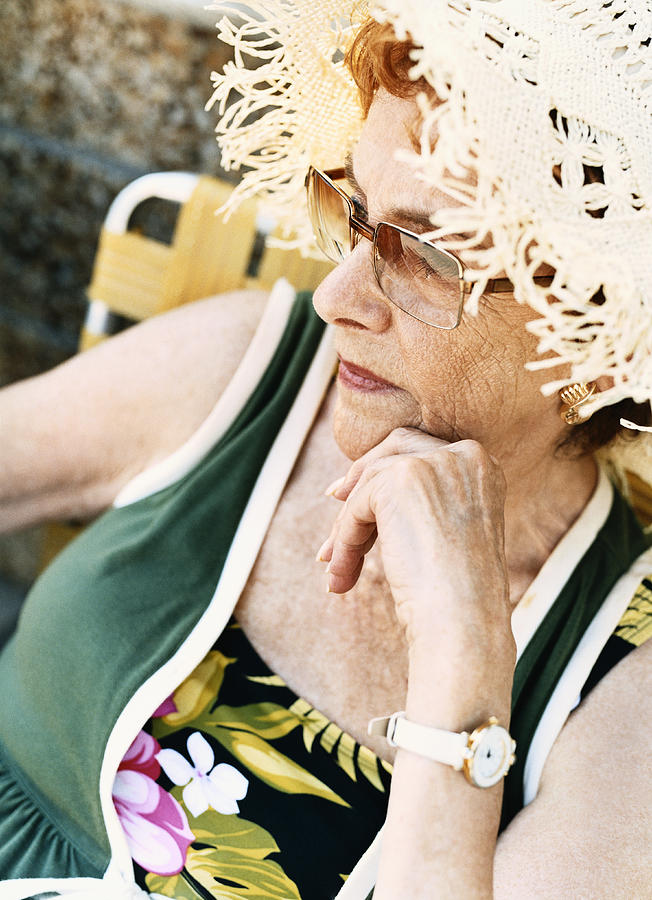 Portrait of a Senior Woman Wearing a Straw hat and Sunglasses Photograph by Digital Vision.