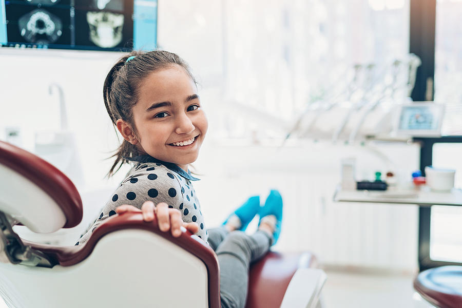 Portrait of a smiling girl sitting on a dentists chair Photograph by Pixelfit