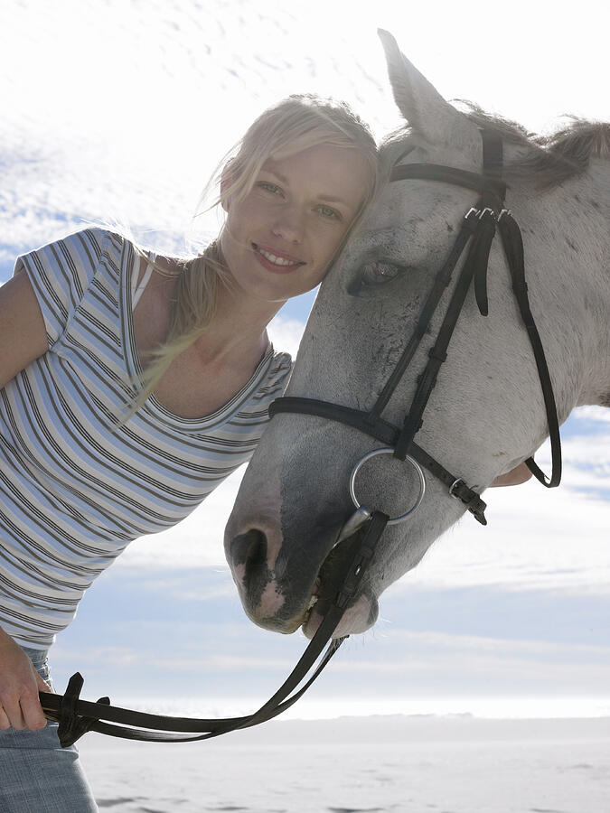 Portrait of a Smiling, Young Woman With Her Horse Photograph by Digital Vision.