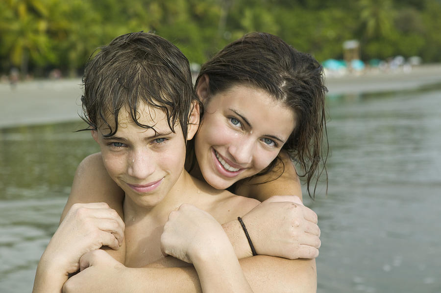 Portrait of a teenage girl holding a teenage boy Photograph by Photodisc