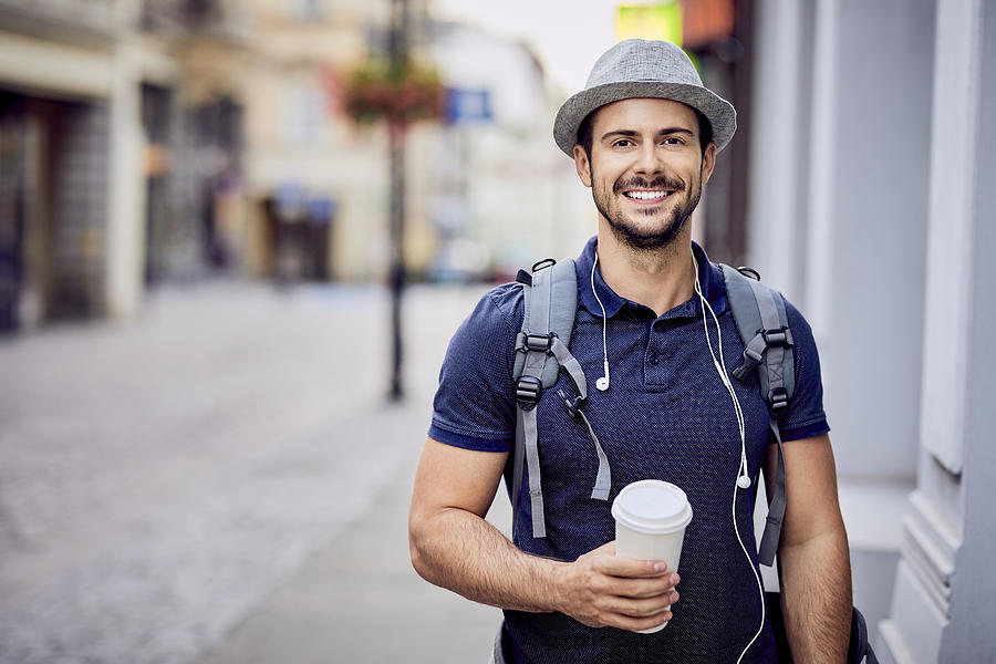 Portrait of a traveler with backpack holding coffee Photograph by Westend61