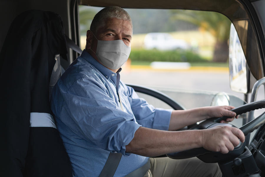 Portrait of a truck driver wearing a facemask to avoid the coronavirus Photograph by Andresr