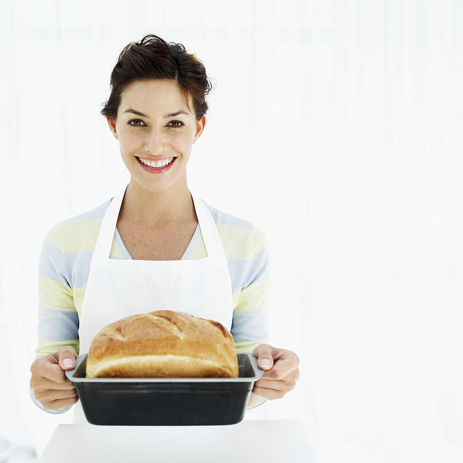Portrait Of A Woman Holding A Baking Tray With Freshly Baked Bread Photograph by Stockbyte