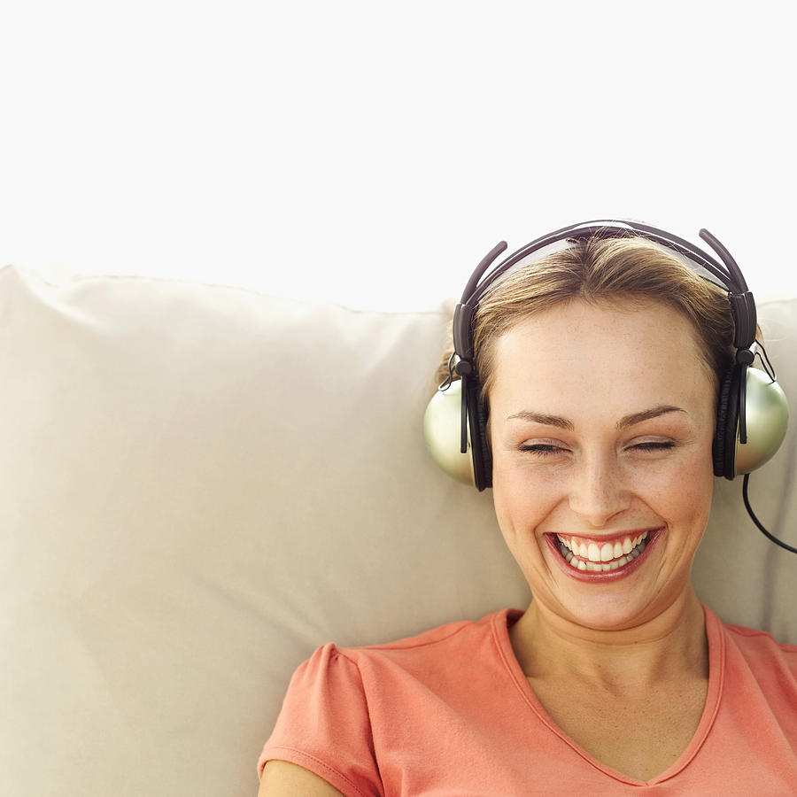 Portrait of a woman wearing headphones smiling Photograph by Stockbyte