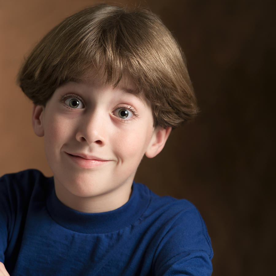Portrait Of A Young Caucasian Boy In A Blue Shirt As He Flashes A Silly Grin Photograph by Photodisc