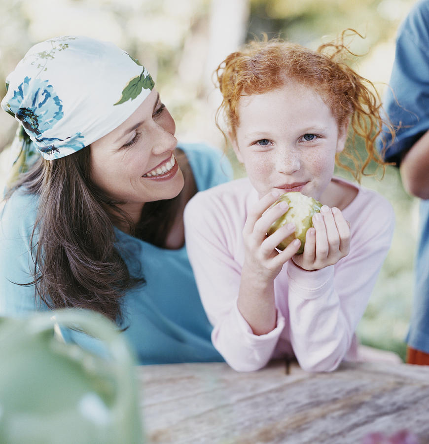 Portrait of a Young Girl and Her Mother, Girl Eating an Apple Photograph by Digital Vision.